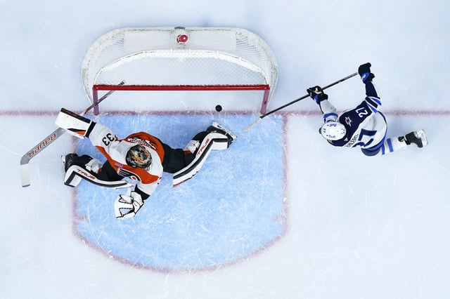 Winnipeg Jets' Nikolaj Ehlers, right, scores a goal against Philadelphia Flyers' Samuel Ersson during the first period of an NHL hockey game Thursday, March 6, 2025, in Philadelphia. (AP Photo/Matt Slocum)