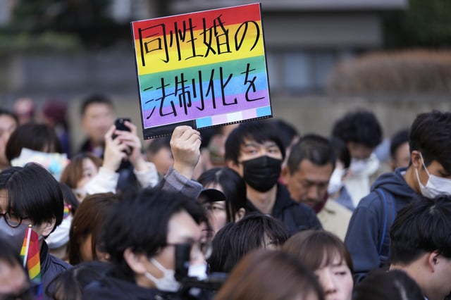 FILE - A supporter for the LGBTQ+ community holds up a poster reading "Legalize the same-sex marriage" as plaintiffs speak in front of media members by the main entrance of the Tokyo district court after hearing the ruling regarding LGBTQ+ marriage rights, in Tokyo, on March 14, 2024. (AP Photo/Hiro Komae, File)