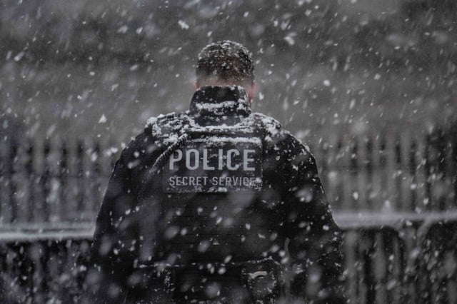A uniformed Secret Service officer stands watch in the snow outside the White House in Washington, DC, on January 19, 2025. (Photo by Jim WATSON/AFP/Getty Images)