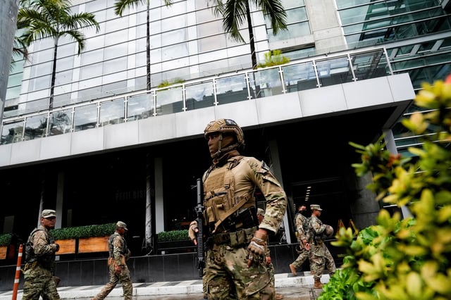 Police stand outside a hotel where migrants mainly from Asia and the Middle East were housed after being deported to Panama by the United States, in Panama City on February 18, 2025.