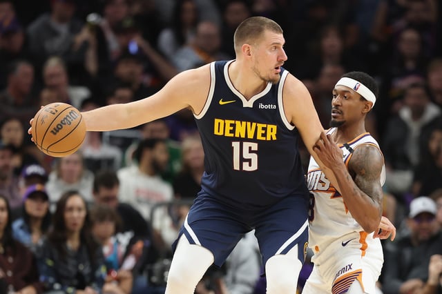 PHOENIX, ARIZONA - DECEMBER 25: Nikola Jokic #15 of the Denver Nuggets handles the ball against Bradley Beal #3 of the Phoenix Suns during the second half of the NBA game at Footprint Center on December 25, 2024 in Phoenix, Arizona.