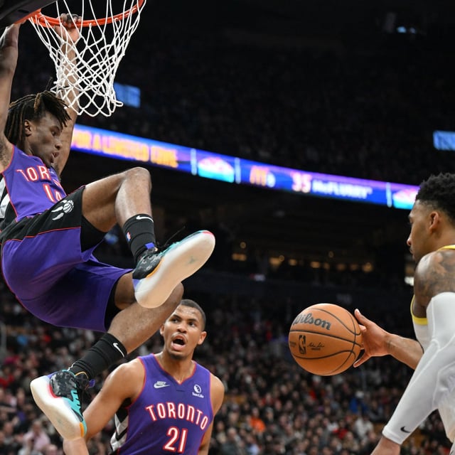 Mar 7, 2025; Toronto, Ontario, CAN; Toronto Raptors guard Ja'Kobe Walter (14) hangs off the rim after dunking for a basket against the Utah Jazz in the first half at Scotiabank Arena. Mandatory Credit: Dan Hamilton-Imagn Images