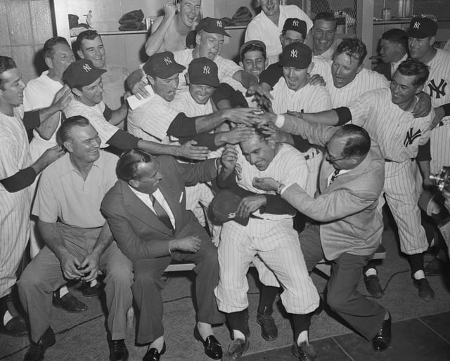 Yankee catcher Yogi Berra is the center of this scene of joy and jubilation after the New York Yankees clinched their record-breaking fifth straight pennant in 1953.