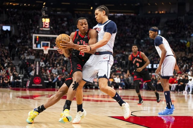 Toronto Raptors guard Scottie Barnes (4) drives the net against defending Washington Wizards forward Kyshawn George (18) during the first half of NBA action in Toronto on Saturday, March 8, 2025. THE CANADIAN PRESS/Thomas Skrlj