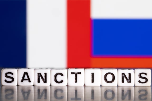 Plastic letters arranged to read "Sanctions" are placed in front the flag colors of France and Russia in this illustration taken February 28, 2022. REUTERS/Dado Ruvic/Illustration/File Photo