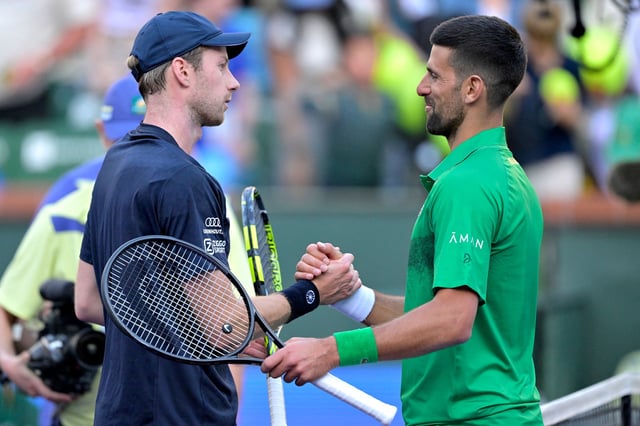 Novak Djokovic shakes hand with Botic van de Zandschlup after their match.