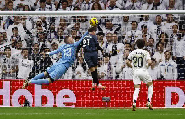 Soccer Football - LaLiga - Real Madrid v Rayo Vallecano - Santiago Bernabeu, Madrid, Spain - March 9, 2025 Real Madrid's Andriy Lunin in action with Rayo Vallecano's Adri Embarba REUTERS/Susana Vera