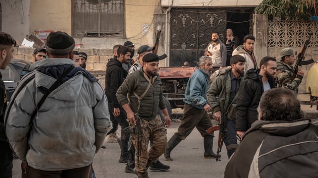 Des membres de la police et des forces du nouveau pouvoir syrien tentent de dégager une place près du poste de police de Jableh.