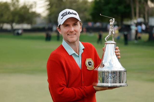 Russell Henley holds the champions trophy after winning the Arnold Palmer Invitational golf tournament.