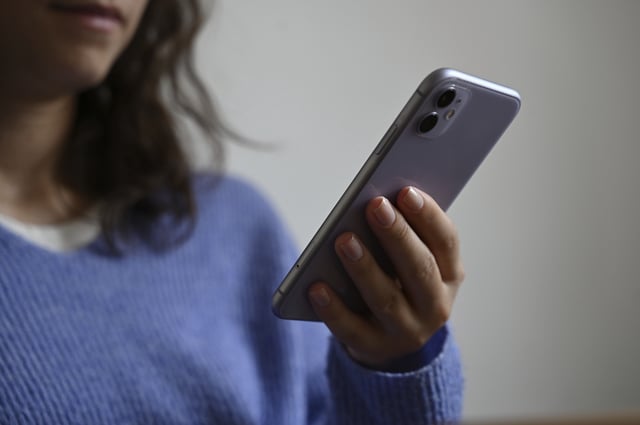 A woman holding a smartphone in her hand in Berlin, Germany, photographed on July 5, 2024.