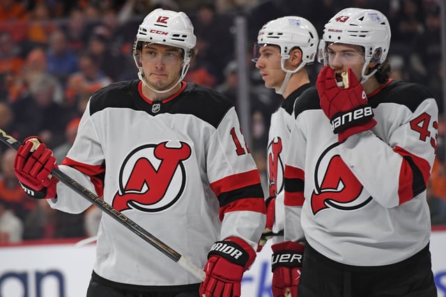 Mar 9, 2025; Philadelphia, Pennsylvania, USA; New Jersey Devils center Cody Glass (12) and defenseman Luke Hughes (43) against the Philadelphia Flyers at Wells Fargo Center. Mandatory Credit: Eric Hartline-Imagn Images