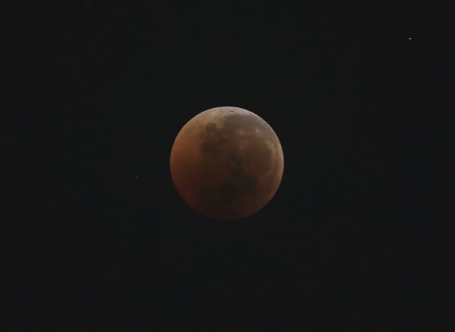 A blood moon rises over Jakarta during a lunar eclipse Saturday, July 28, 2018. Skywatchers around much of the world are looking forward to a complete lunar eclipse that will be the longest this century.