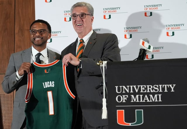 Miami Vice President and Director of Athletics Dan Radakovich, right, poses for a photograph as he introduces Jai Lucas, left, as the new head coach for Miami’s NCAA college basketball team, Monday, March 10, 2025, in Coral Gables, Fla. (AP Photo/Lynne Sladky)