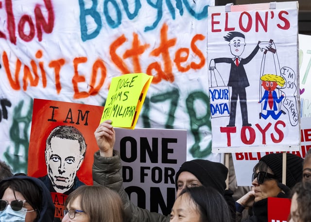People hold up signs during a protest in support of the Consumer Financial Protection Bureau (CFPB), Monday, Feb. 10, 2025, at CFPB headquarters in Washington. (AP Photo/Jacquelyn Martin)