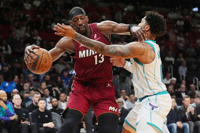 Miami Heat center Bam Adebayo (13) dribbles the ball as Charlotte Hornets forward Miles Bridges (0) defends during the first half of an NBA basketball game, Monday, March 10, 2025, in Miami. (AP Photo/Marta Lavandier)