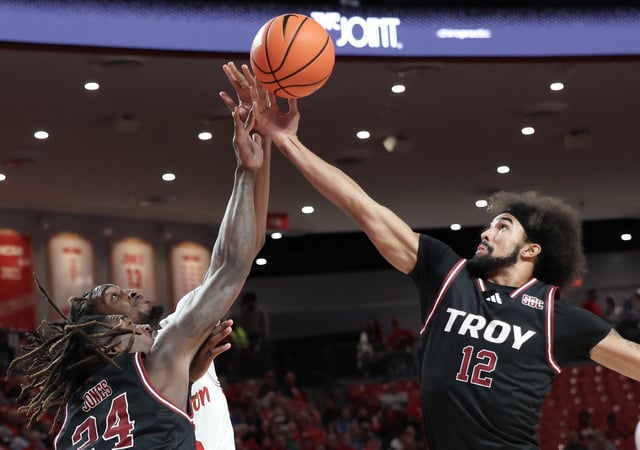 Dec 10, 2024; Houston, Texas, USA; Troy Trojans center Randarius Jones (24) and guard Tayton Conerway (12) reach for a defensive rebound against Houston Cougars guard Mylik Wilson (8) in the first half at Fertitta Center. Mandatory Credit: Thomas Shea-Imagn Images/File Photo
