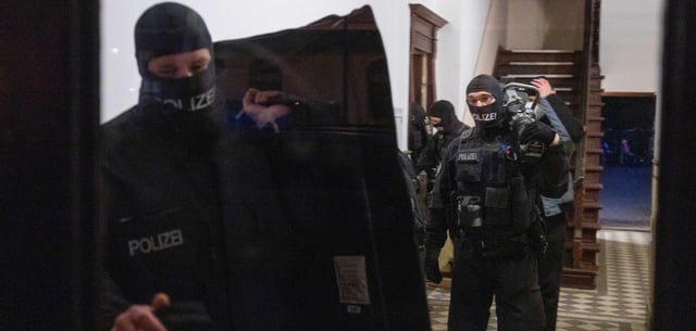 Polizisten durchsuchen ein Wohngebäude in Berlin