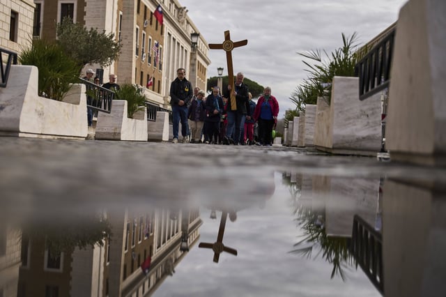 Christian Catholic worshippers pray as they walk towards St. Peter's Square, in Rome, Monday, March 10, 2025. (AP Photo/Francisco Seco)
