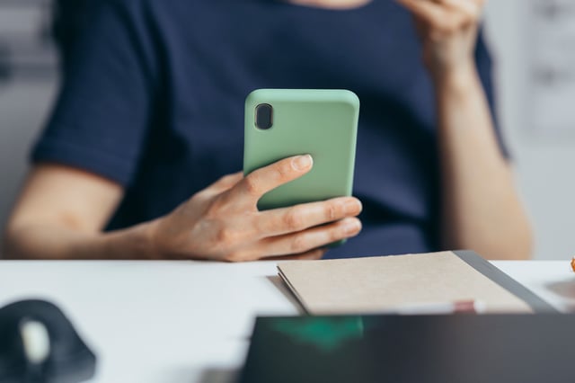 An unrecognizable person enjoying spending time on the mobile phone.