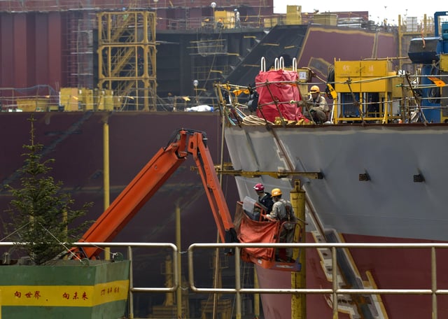 FILE - Workers construct the hull of a vessel at the STX shipbuilding plant on Changxing Island, on the outskirt of Dalian, in northeast China's Liaoning province, Sept. 15, 2011. (AP Photo/Andy Wong, File)