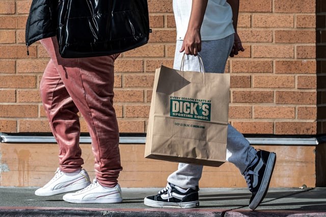 A shopper carries a bag outside a Dick's Sporting Goods store in Daly City, Calif., on March 10, 2025.