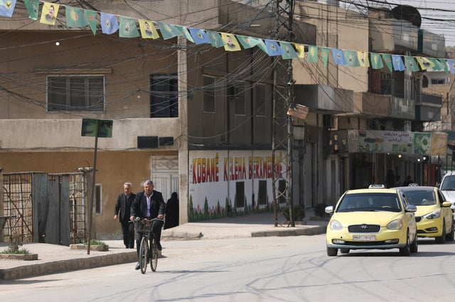 A man rides a bicycle, after the Kurdish-led and U.S.-backed Syrian Democratic Forces (SDF), which controls much of Syria's oil-rich northeast, signed a deal agreeing to integrate into Syria's new state institutions, the Syrian presidency said on Monday, in Qamishli, Syria, March 11, 2025. REUTERS/Orhan Qereman