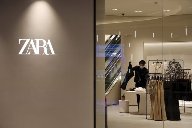 A staff member sorts clothes inside a clothing store of Inditex's Zara brand at a newly opened shopping mall in Beijing, China April 16, 2021. REUTERS/Tingshu Wang/File Photo