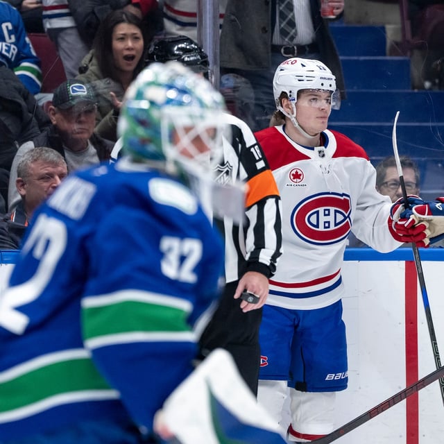 Montreal Canadiens' Cole Caufield (13) celebrates his goal on Vancouver Canucks goaltender Kevin Lankinen (32) with Nick Suzuki (14) during the second period of an NHL hockey game in Vancouver, B.C., on Tuesday, March 11, 2025. THE CANADIAN PRESS/Ethan Cairns