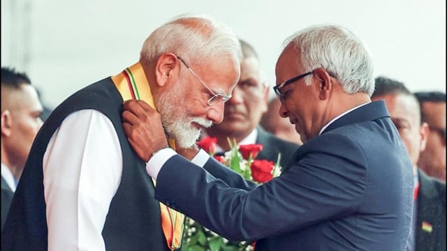 Prime Minister Narendra Modi receives the Highest National Award of Mauritius, the Grand Commander of the Order of the Star and Key of the Indian Ocean from Mauritius President Dharambeer Gokhool at Mauritius’ National Day Celebrations, in Port Louis on Wednesday. (DPR PMO)