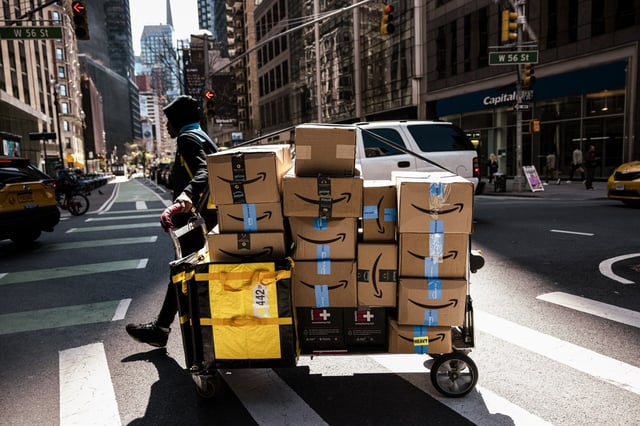 An Amazon contract worker pulls a cart of packages for delivery in New York City, on April 22, 2024. 
