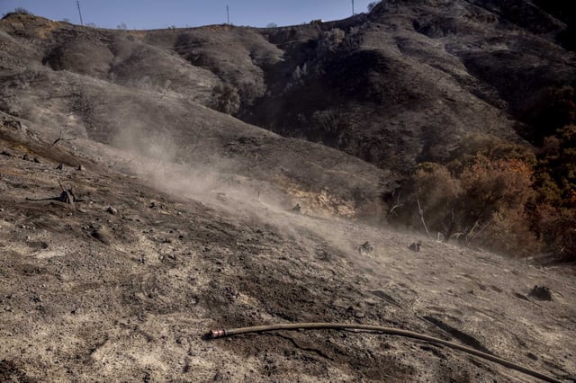 Dust from a burned hillside, commonly referred to as moonscape by firefighters is seen on a hill during the Palisades Fire near the Tarzana neighborhood of Los Angeles in January. 