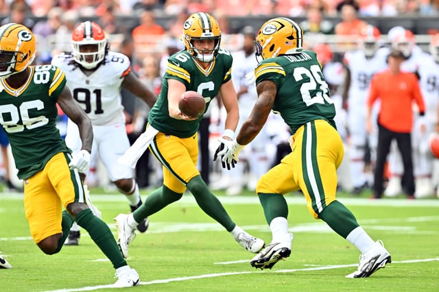 Quarterback Sean Clifford #6 hands off to running back AJ Dillon #28 of the Green Bay Packers during the first half of a preseason game against the Cleveland Browns at Cleveland Browns Stadium.