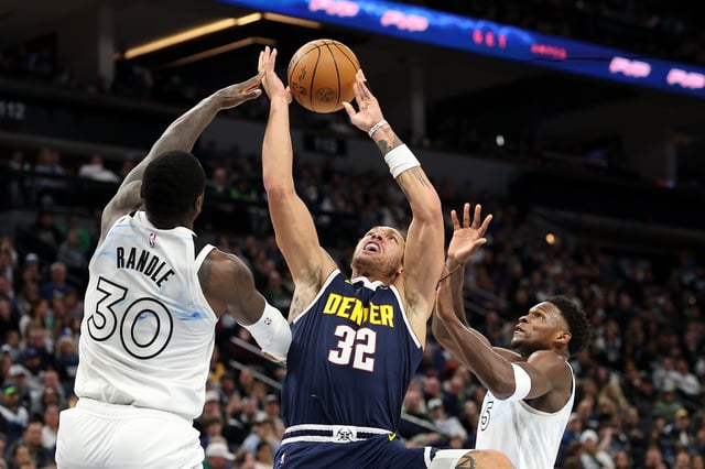 Aaron Gordon #32 of the Denver Nuggets goes up for a shot against Julius Randle #30 of the Minnesota Timberwolves and Anthony Edwards #5 during the third quarter at Target Center on January 25, 2025 in Minneapolis, Minnesota.