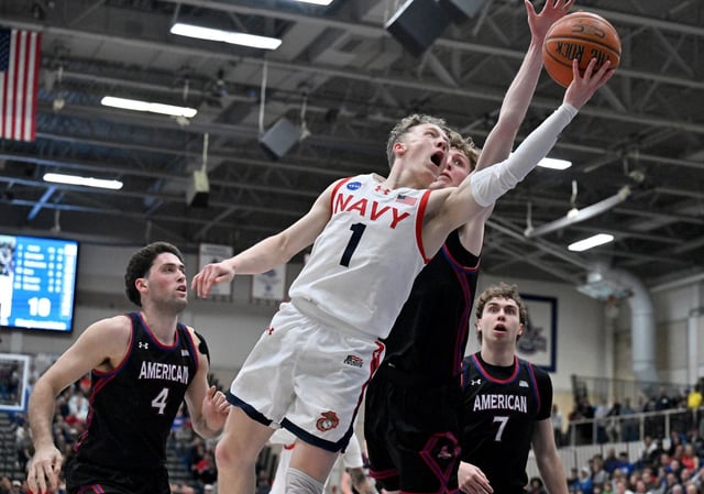 Navy’s Austin Benigni goes for a layup as American’s Matt Mayock tries to stop him in the first half. The visiting Navy Midshipmen play the American Eagles in the Patriot League men’s championship basketball game at Bender Arena. (Paul W. Gillespie/Staff)