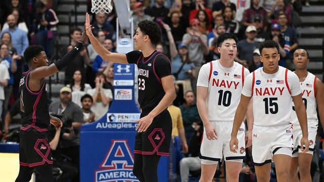American’s Elijah Stephens, left, and American’s Greg Jones, right, high five after scoring with little time left on the clock. The American Eagles defeated the visiting Navy Midshipmen, 74-52, to win Patriot League men’s championship basketball game at Bender Arena. (Paul W. Gillespie/Staff)