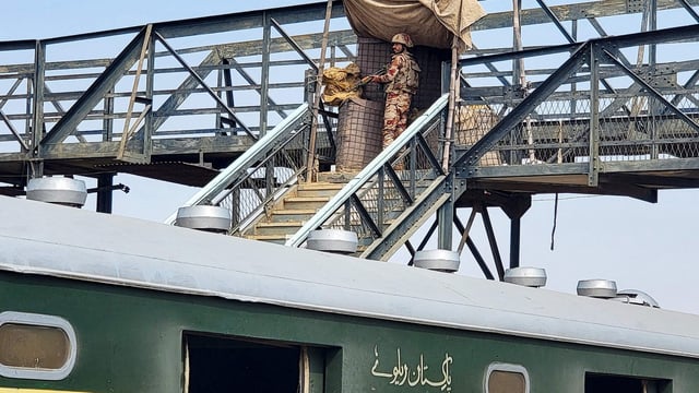 A paramilitary soldier stands guard at a railway station in the Sibi district of southwestern Balochistan province during a security operation against militants a day after they hijacked a passenger train.