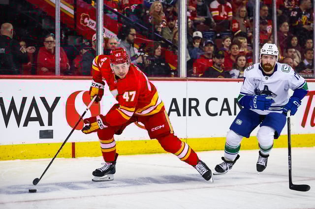 Mar 12, 2025; Calgary, Alberta, CAN; Calgary Flames center Connor Zary (47) controls the puck against Vancouver Canucks defenseman Filip Hronek (17) during the second period at Scotiabank Saddledome. Mandatory Credit: Sergei Belski-Imagn Images/File Photo