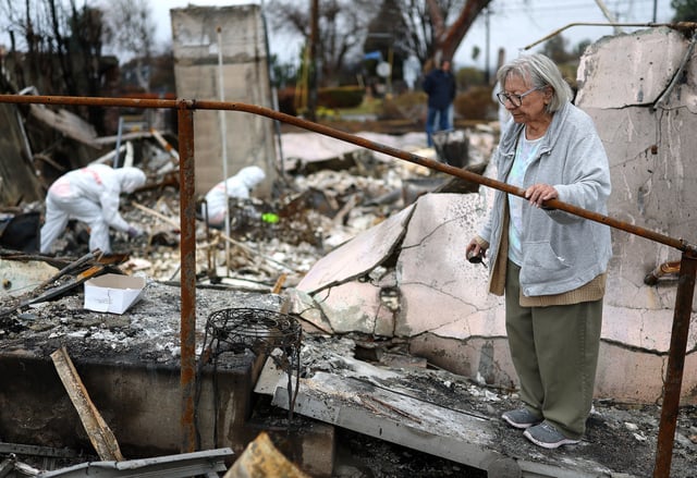 Volunteers with Samaritan&#39;s Purse help Emma Alvarado (R) search for personal items in the ashes of her family home which burned in the Eaton Fire on February 05, 2025 in Altadena, California.
