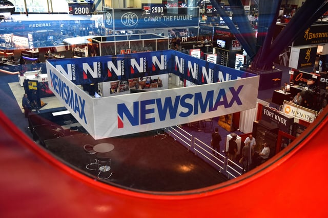A Newsmax booth broadcasts as attendees try out the guns on display at the National Rifle Association (NRA) annual convention in Houston, Texas, U.S. May 29, 2022. Picture taken through glass. REUTERS/Callaghan O'Hare