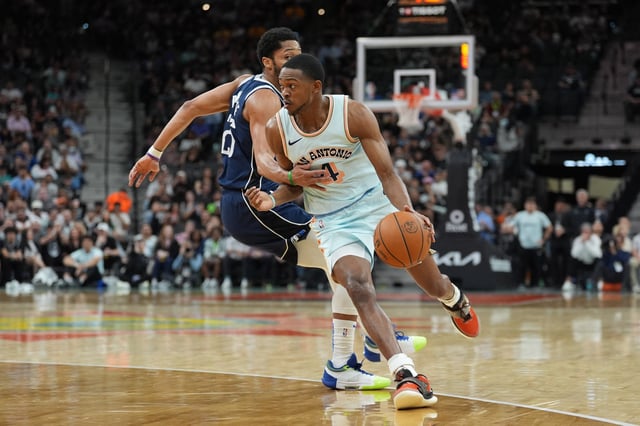 Mar 12, 2025; San Antonio, Texas, USA; San Antonio Spurs guard De'Aaron Fox (4) dribbles past Dallas Mavericks guard Spencer Dinwiddie (26) in the first half at Frost Bank Center. Mandatory Credit: Daniel Dunn-Imagn Images/File Photo