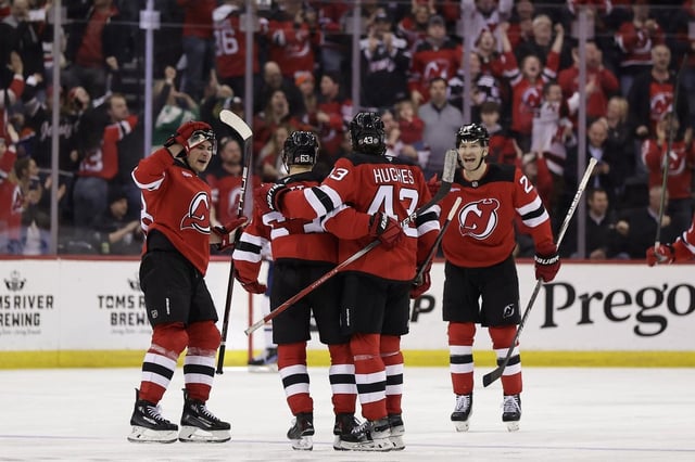 New Jersey Devils left wing Jesper Bratt (63) is congratulated by teammates after scoring during the third period of an NHL hockey game against the Edmonton Oilers, Thursday, March 13, 2025, in Newark, N.J. (AP Photo/Adam Hunger)