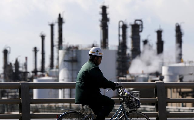 A worker cycles near a factory at the Keihin industrial zone in Kawasaki, Japan February 17, 2016.  REUTERS/Toru Hanai/File Photo