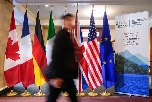 A man walk past the G7 members flags at the Manoir Richelieu before the G7 Foreign Ministers summit in La Malbaie, Quebec, Canada March 12, 2025.  REUTERS/Mathieu Belanger/File Photo