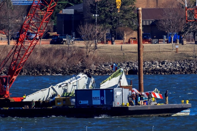 A crane retrieves part of the wreckage from the Potomac River, in the aftermath of the collision of American Eagle flight 5342 and a Black Hawk helicopter that crashed into the river, by the Ronald Reagan Washington National Airport, in Arlington, Virginia, U.S., February 4, 2025. REUTERS/Eduardo Munoz/File Photo