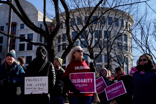 Consumer Financial Protection Bureau (CFPB) workers hold placards as they rally on the day of a hearing in a case on the Trump administration's mass firings of CFPB workers, outside the U.S. District Court in Washington, D.C., U.S., March 3, 2025. REUTERS/Kent Nishimura/File Photo