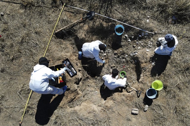 FILE - Forensic technicians excavate a field on a plot of land referred to as a cartel "extermination site" where burned human remains are buried, on the outskirts of Nuevo Laredo, Mexico, Feb. 8, 2022. (AP Photo/Marco Ugarte, File)