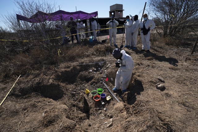 FILE - Forensic technicians excavate a field on a plot of land referred to as a cartel "extermination site" where burned human remains are buried, on the outskirts of Nuevo Laredo, Mexico, Feb. 8, 2022. (AP Photo/Marco Ugarte, File)
