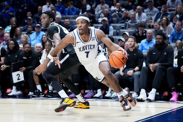 Ryan Conwell #7 of the Xavier Musketeers dribbles the ball while being guarded by Oswin Erhunmwunse #55 of the Providence Friars in the first half. Xavier would go on to win this game.