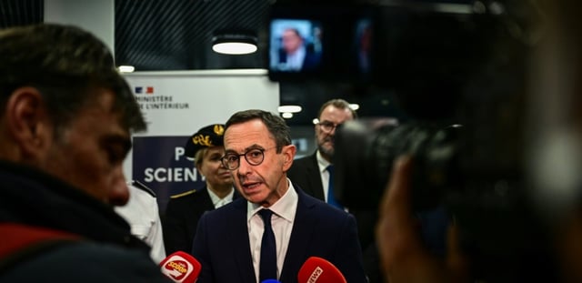 Le ministre de l'Intérieur Bruno Retailleau (c) fait une déclaration à la presse lors de sa visite à Ecully, près de Lyon, pour l'inauguration de l'école nationale de police scientifique, le 14 mars 2025 dans le Rhône