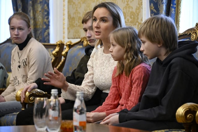 Ukrainian children sit next to Russia’s presidential commissioner for children’s rights, Maria Lvova-Belova, before their departure to Ukraine in February last year (Photo: Alexander Nemenov/AFP)